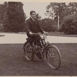 [Man seated on motor cycle]