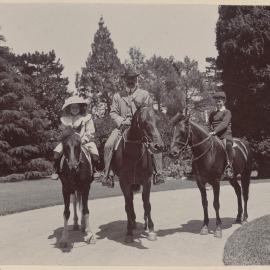 [A man and two children on mounted on horses]