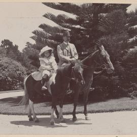 [Man and young girl mounted on horses]