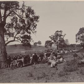 [Group of people watching motor vehicle race]