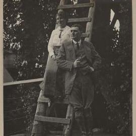 [Woman and man posing on ladder]