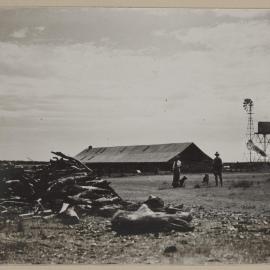 [Man and woman in front of farm shed]