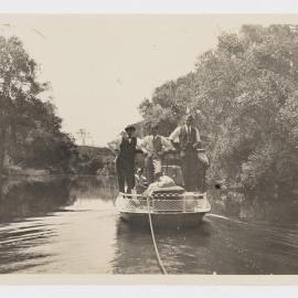 [Three men standing on stern of boat]