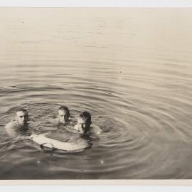 [Three men swimming in river]