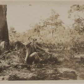 [Man seated beneath tree drinking from bottle], The Stony Rises