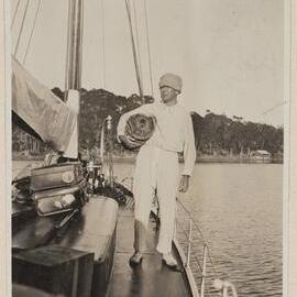 [Man standing on deck of yacht]